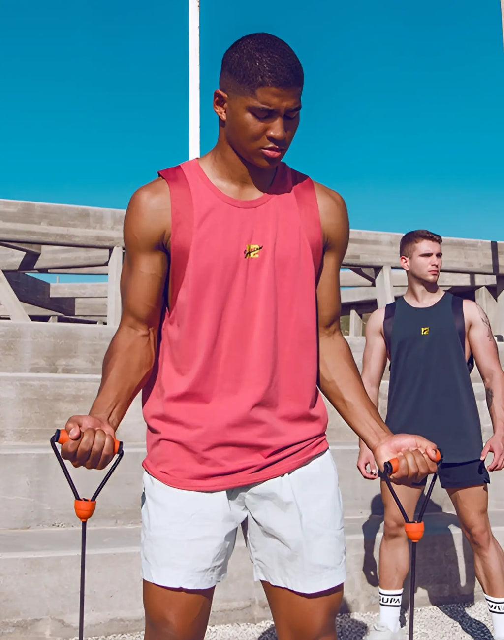 Orange and black textured grip resistance band handles paired with supawear sport tank top dusty cedar rose