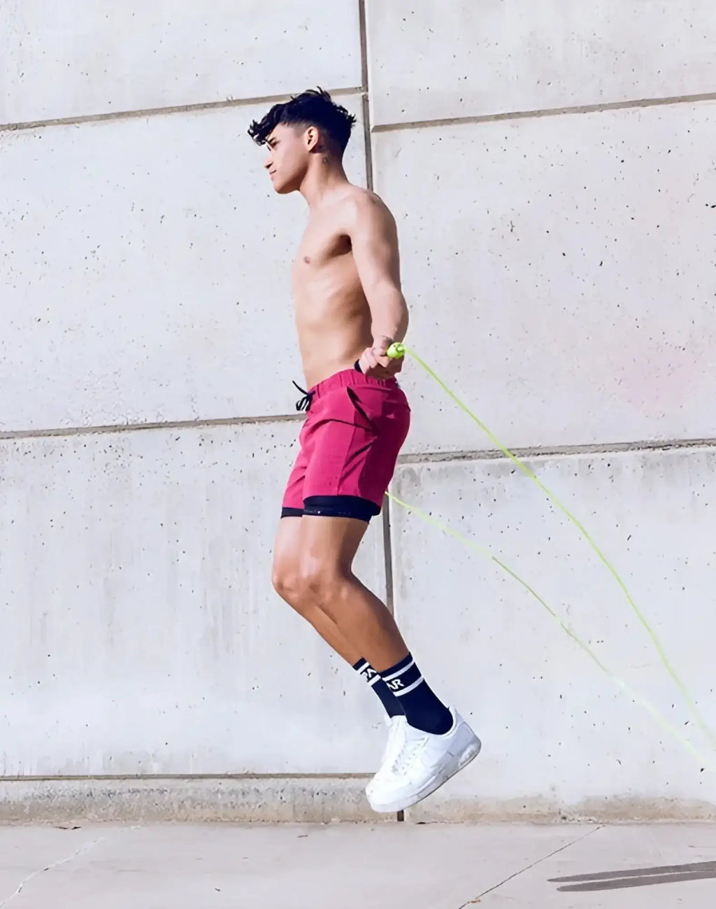 A man jumping rope wearing supawear spr max shorts redbud with vibrant red color and black inner lining