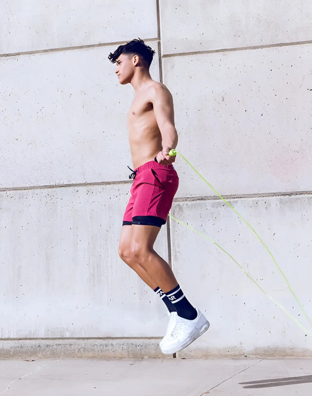 A man jumping rope wearing supawear spr max shorts redbud with vibrant red color and black inner lining