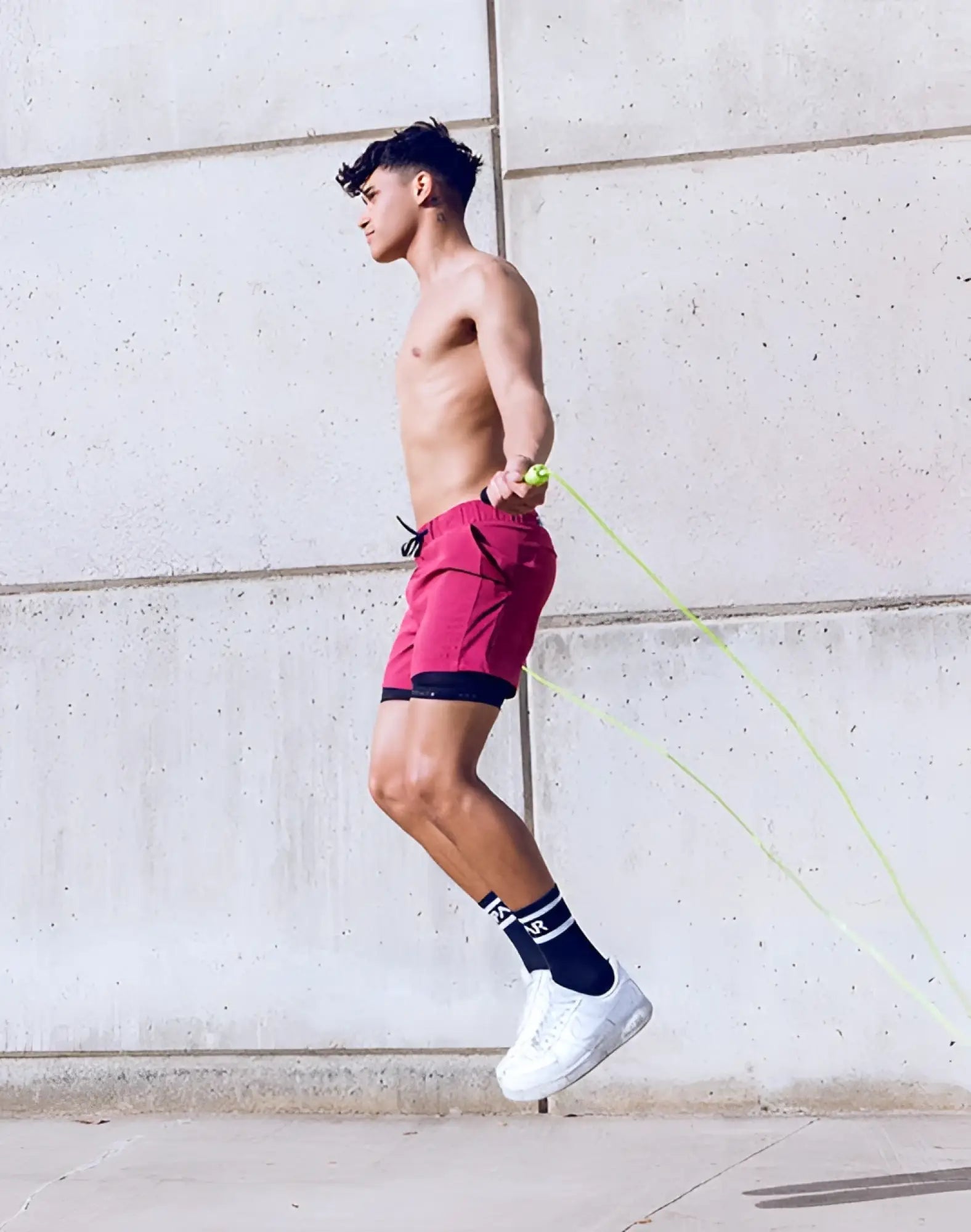 A man jumping rope wearing supawear spr max shorts redbud with vibrant red color and black inner lining