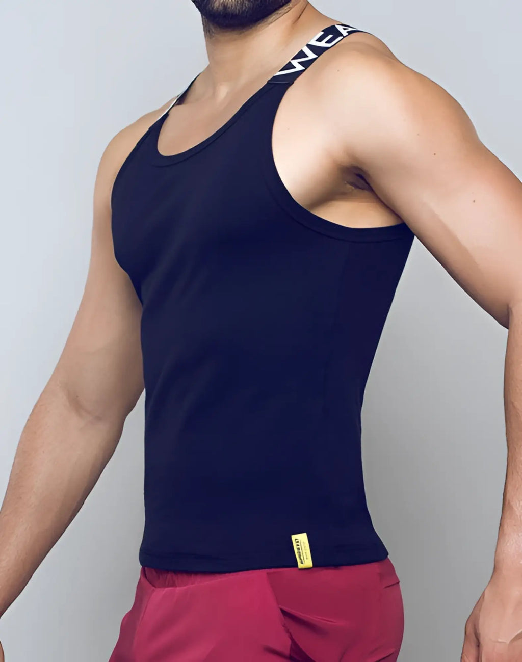 Black SUPAWEAR SPR Max singlet ribbed tank top with white shoulder lettering and small yellow tag at bottom hem