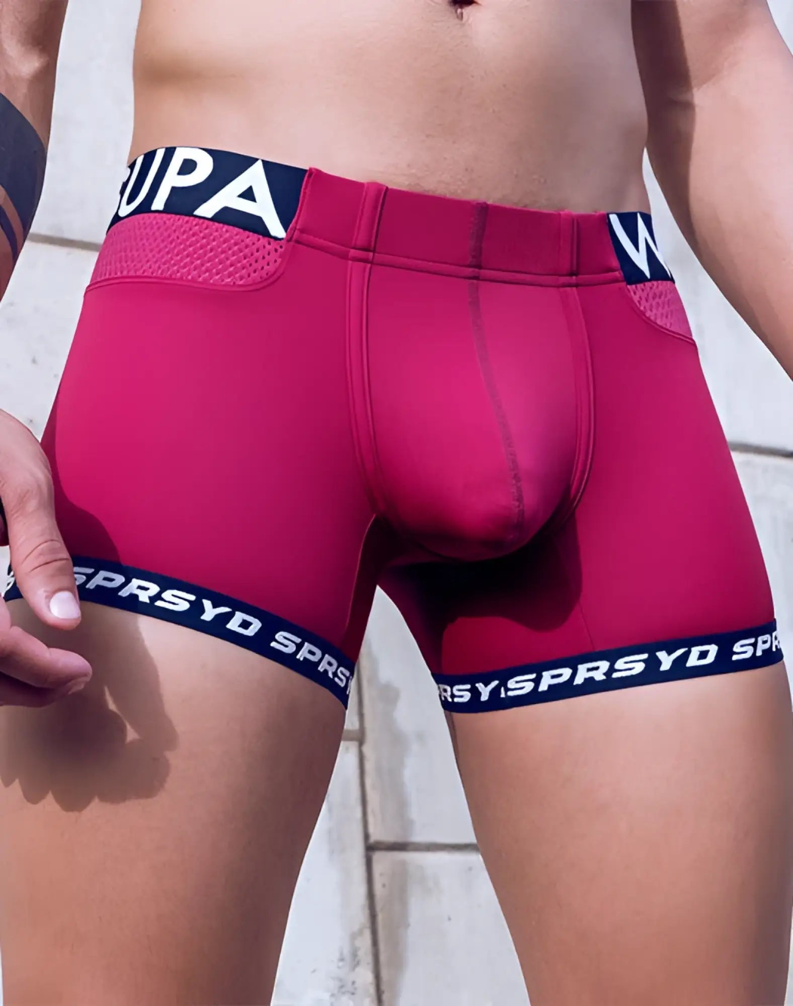 Vibrant fuchsia supawear spr max trunk boxer briefs with navy blue elastic bands featuring white upa and sprsyd branding