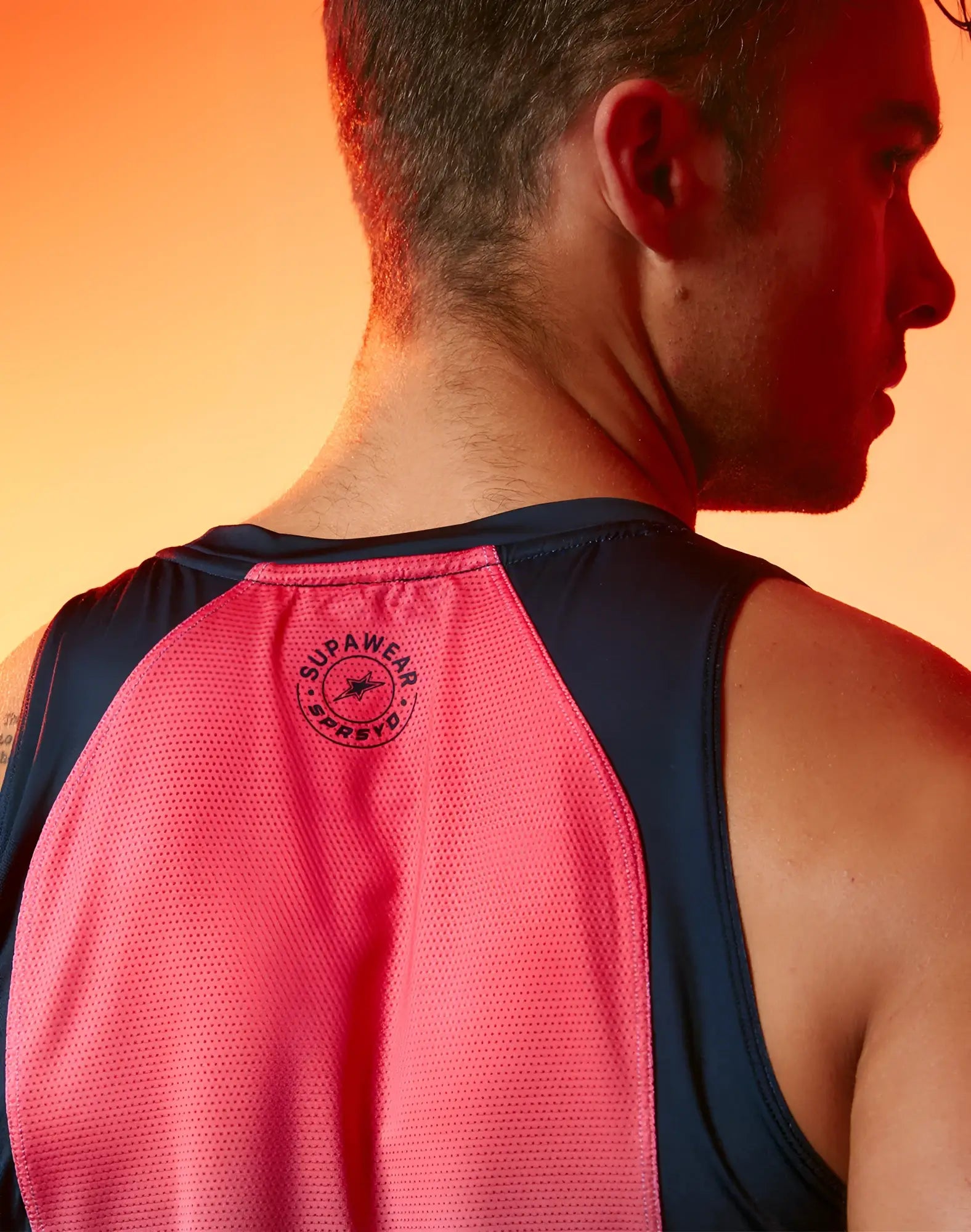 Back view of supawear spr performance gradient singlet rainbow in vibrant pink and navy blue with mesh texture and logo