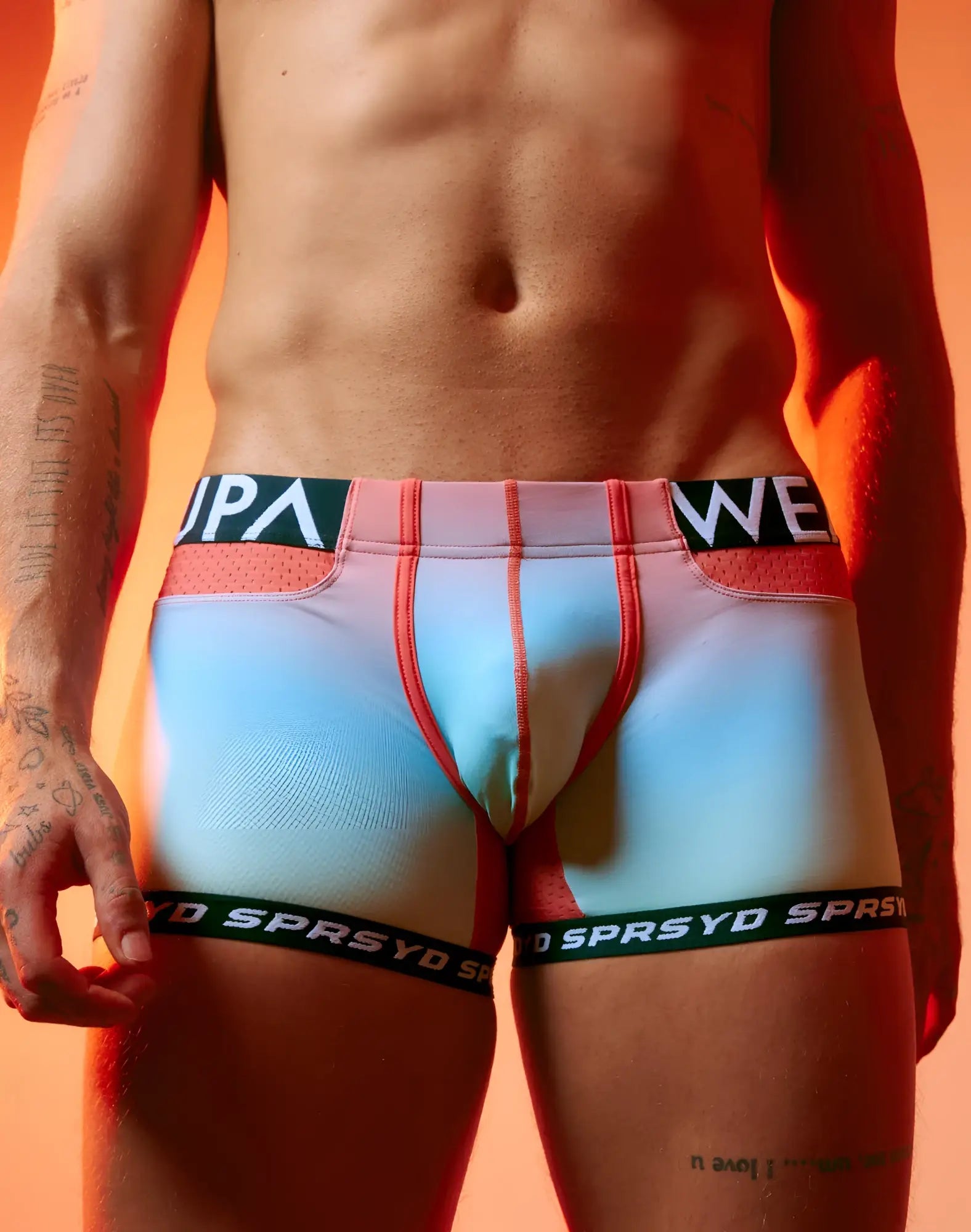 Pastel gradient blue and pink SUPAWEAR SPR performance athletic briefs with red trim and black sprsyd waistband and leg bands