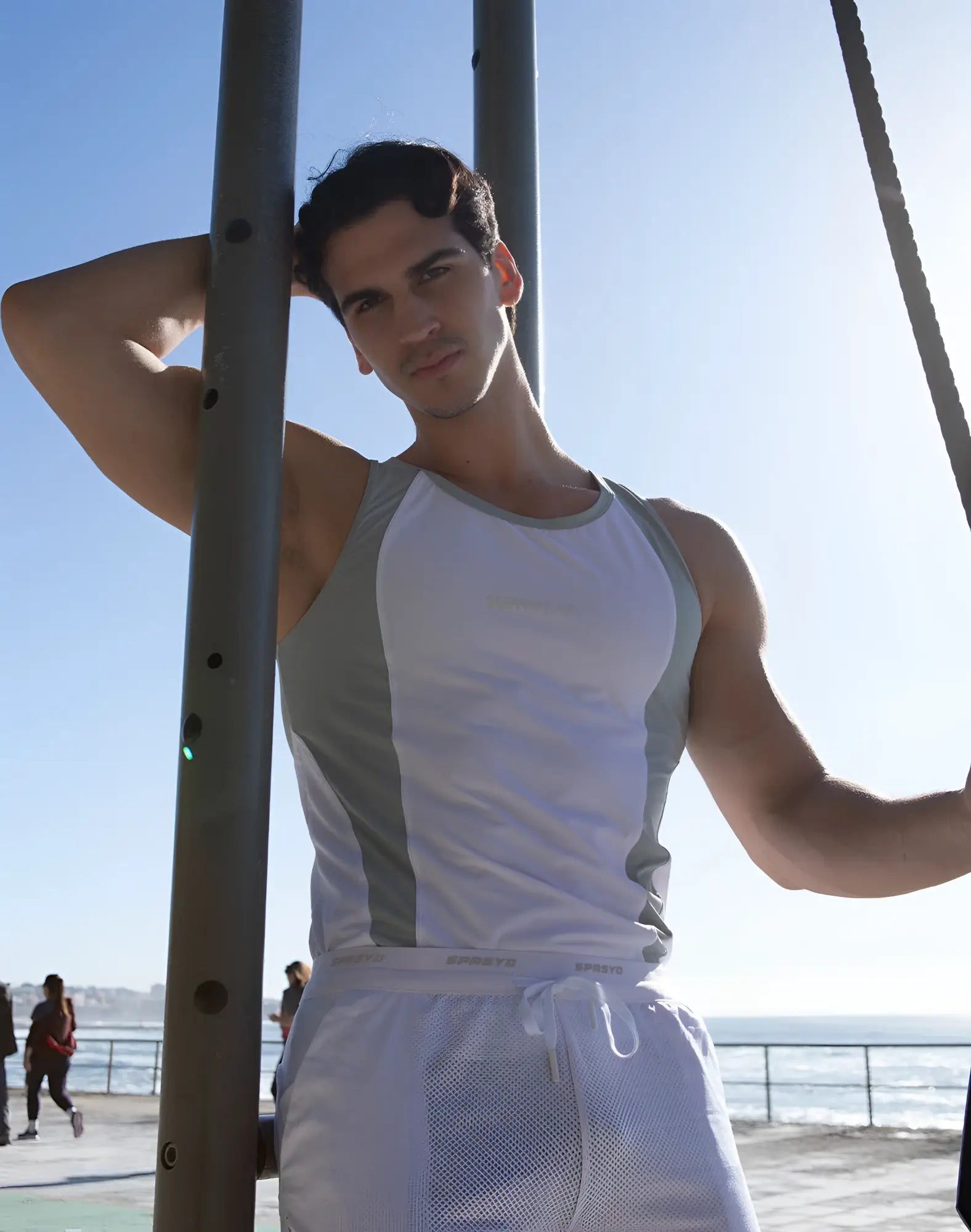 A man wearing a supawear spr performance singlet in white with gray mesh panels for athletic use
