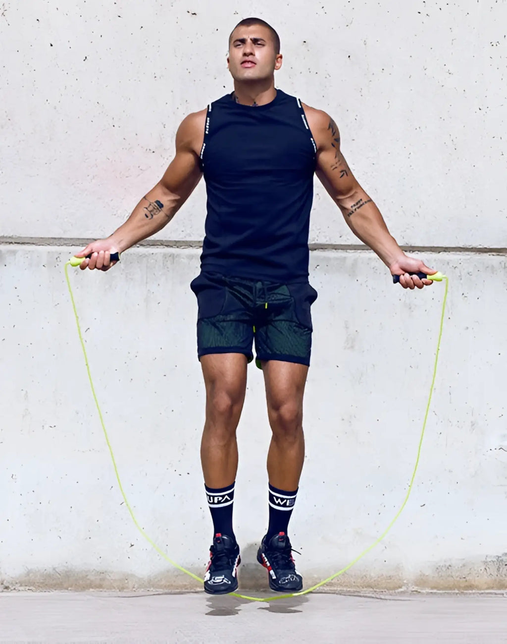 Bright lime green jump rope with black handles featured with SUPAWEAR SPR singlet black product