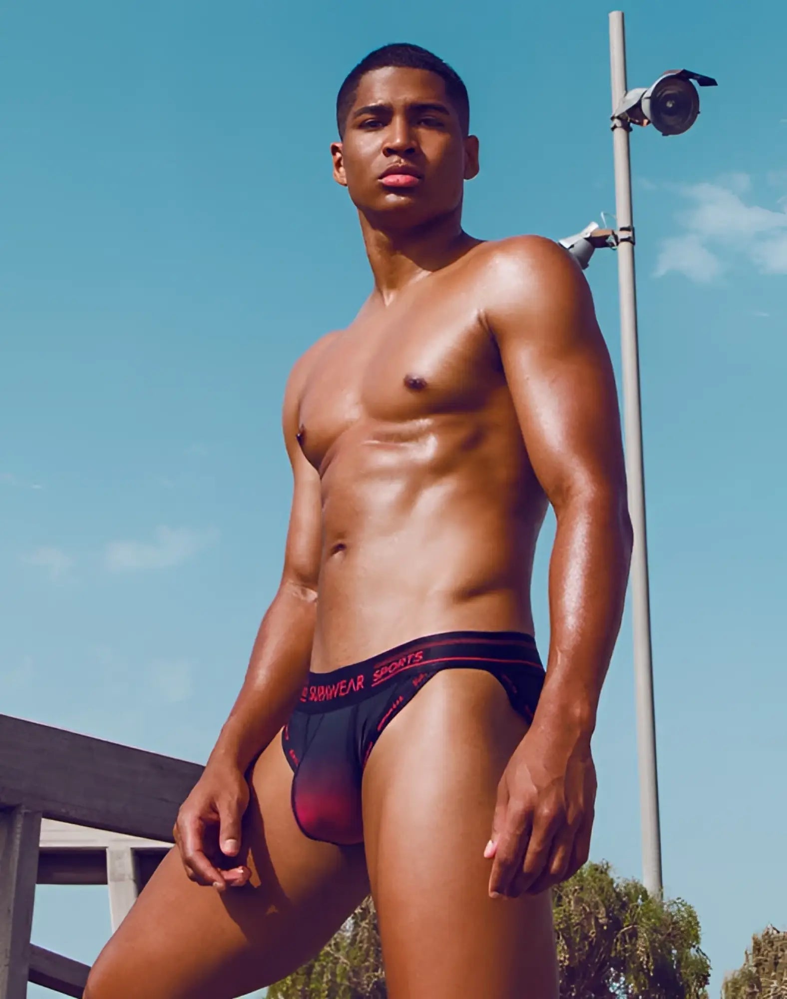 Red and black gradient supawear spr training men’s briefs with sunwear sports branding in pink lettering