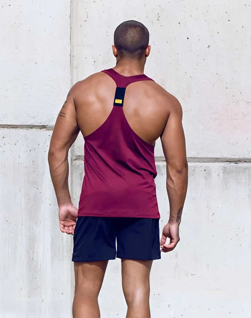 Back view of supawear spr y-tank deep purple maroon athletic tank top with black and yellow branded patch at neck
