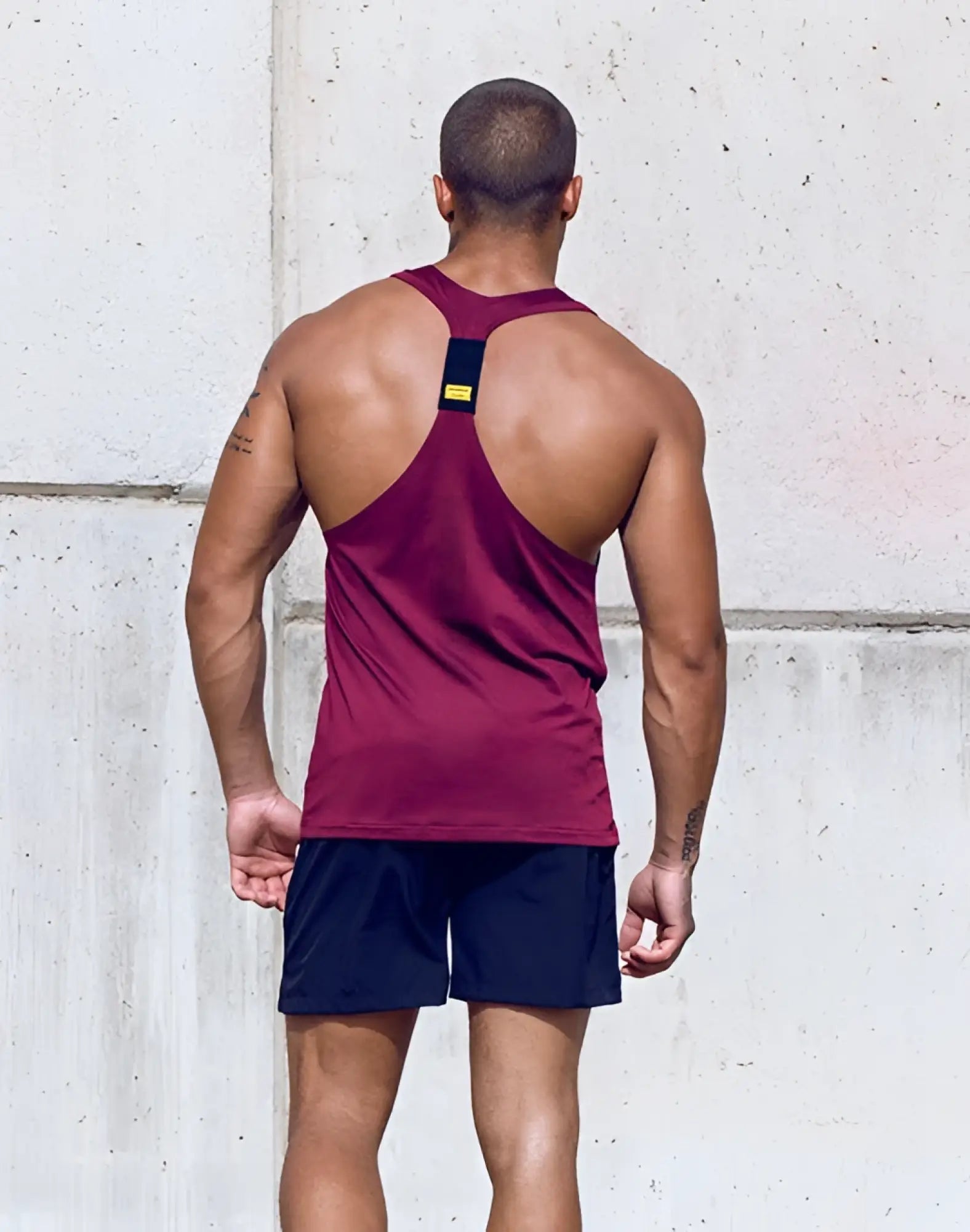 Back view of supawear spr y-tank deep purple maroon athletic tank top with black and yellow branded patch at neck
