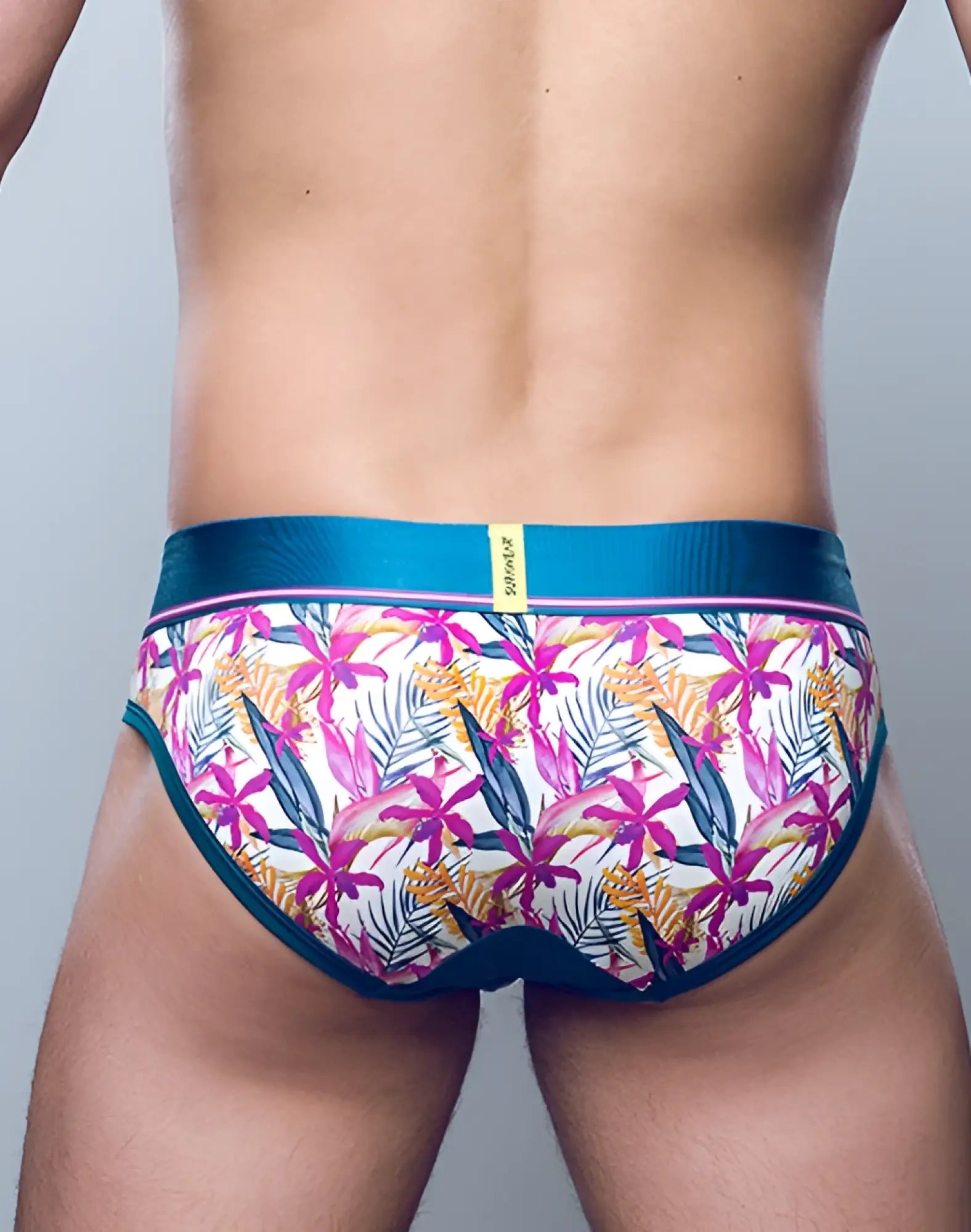 Vibrant tropical floral patterned men’s SUPAWEAR Sprint Brief underwear with teal elastic waistband and trim