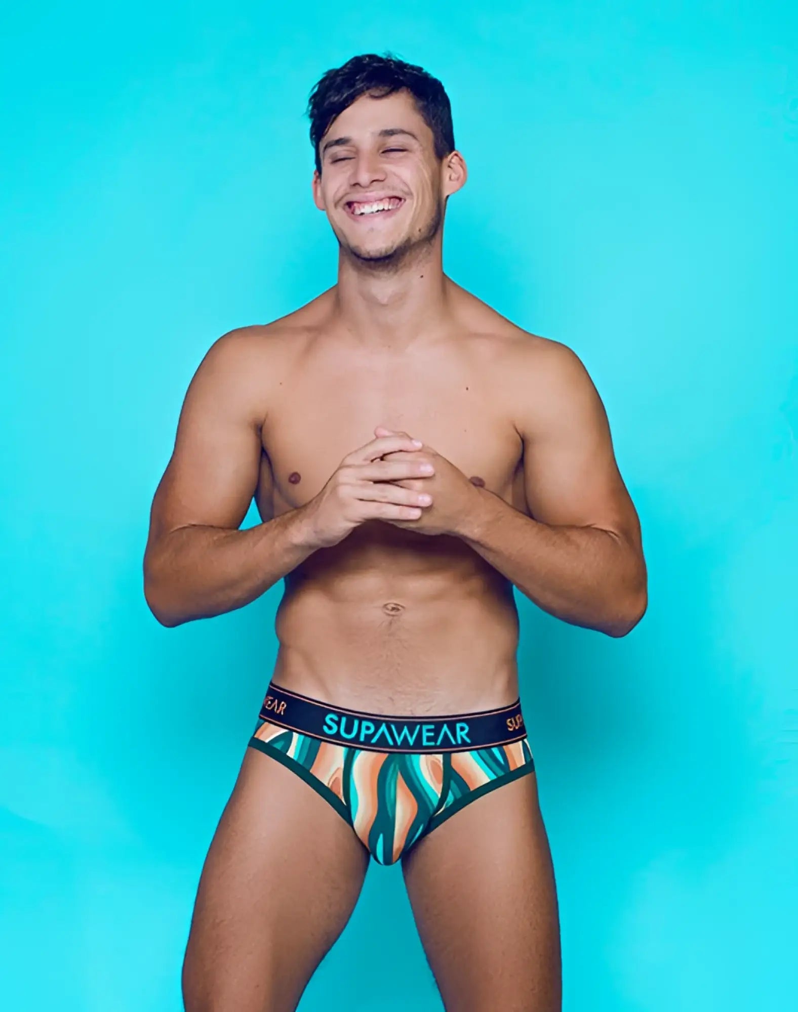 Supawear sprint brief underwear features vibrant teal orange and white abstract waves with a black branded waistband