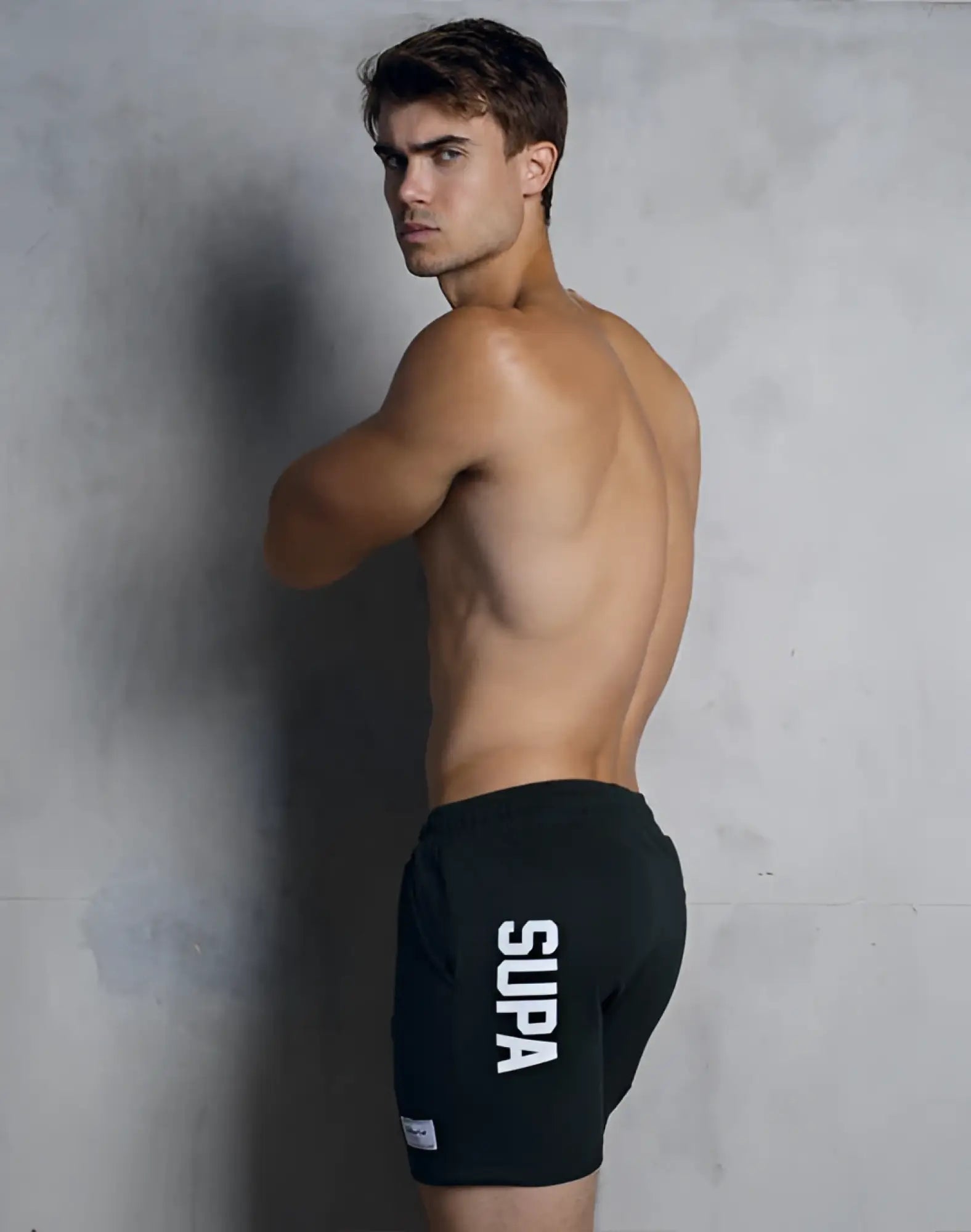 Black supra athletic strike shorts with white vertical lettering on the side for forest workouts