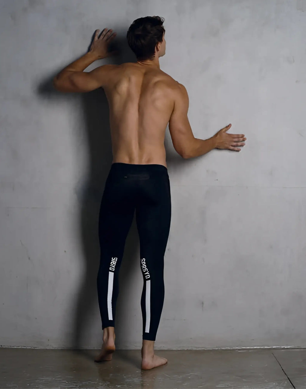 Black supawear strike tights featuring white vertical stripes and sports branding on the sides for athletic use