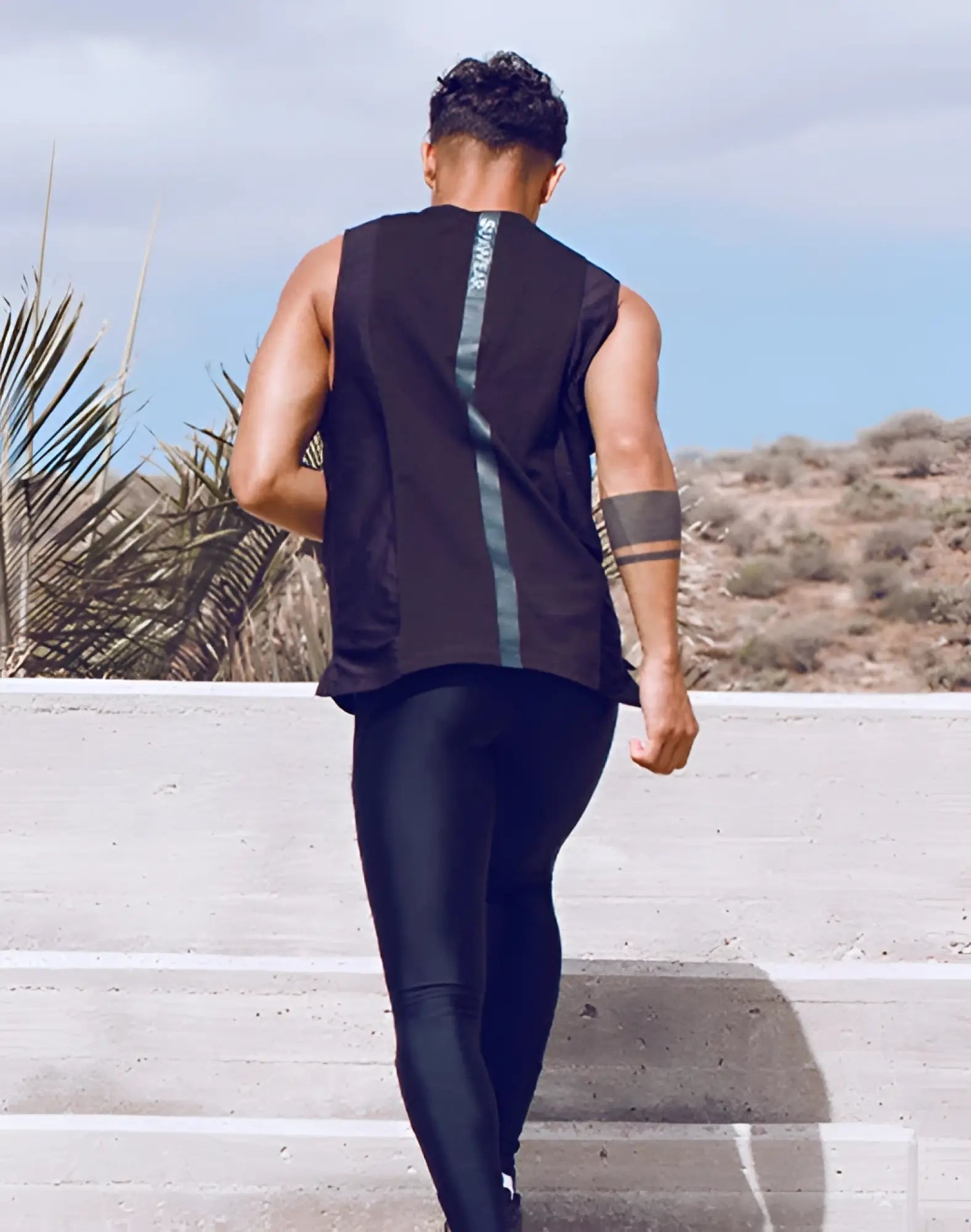 Black sleeveless SUPAWEAR Supa Pro Singlet with vertical gray stripe on back designed for athletic performance