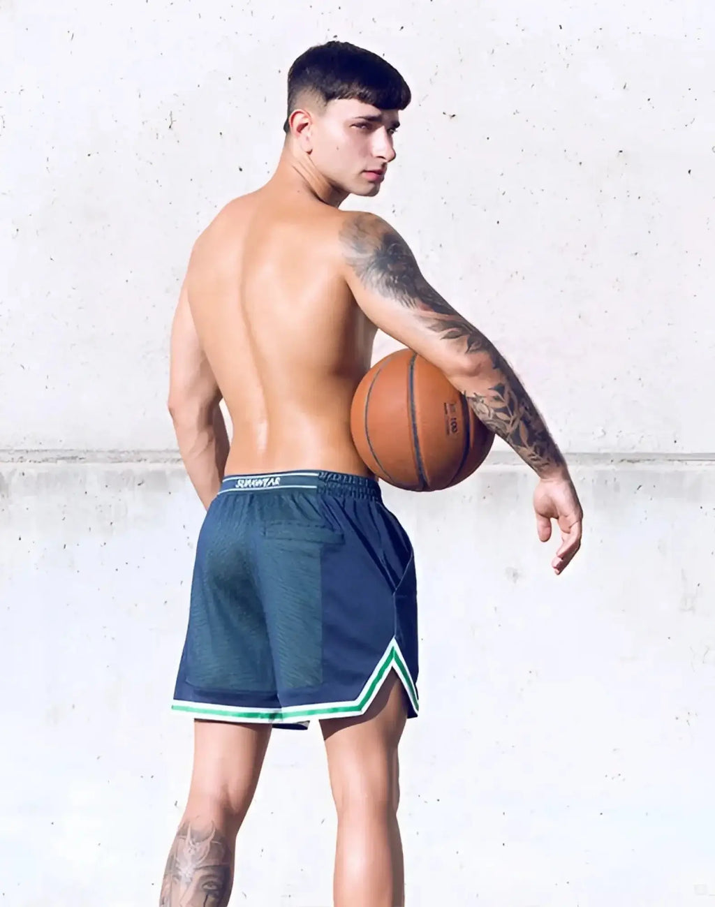 Orange basketball with black seams and white text beside supawear swish mesh shorts in neon green