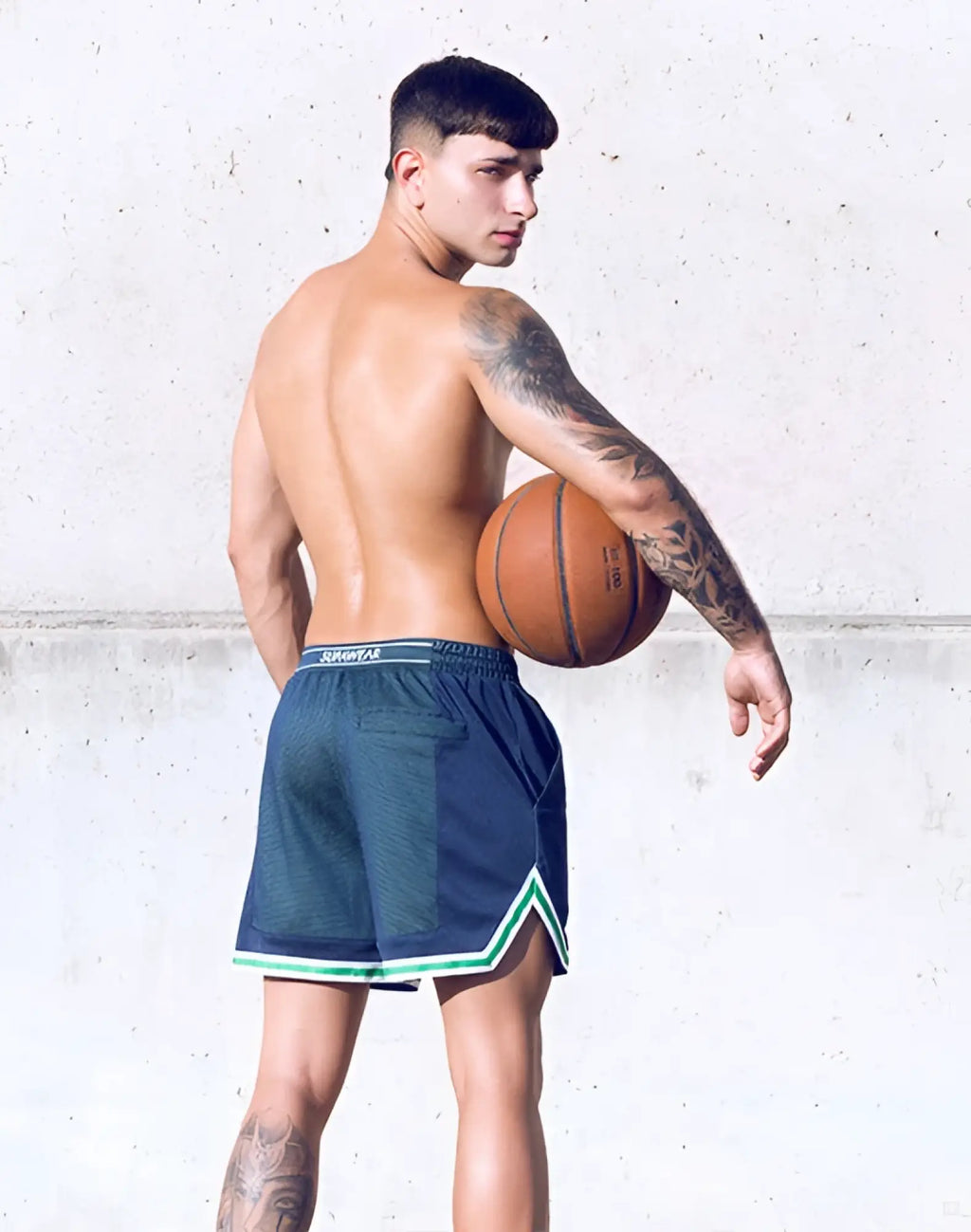 Orange basketball with black seams and white text beside supawear swish mesh shorts in neon green