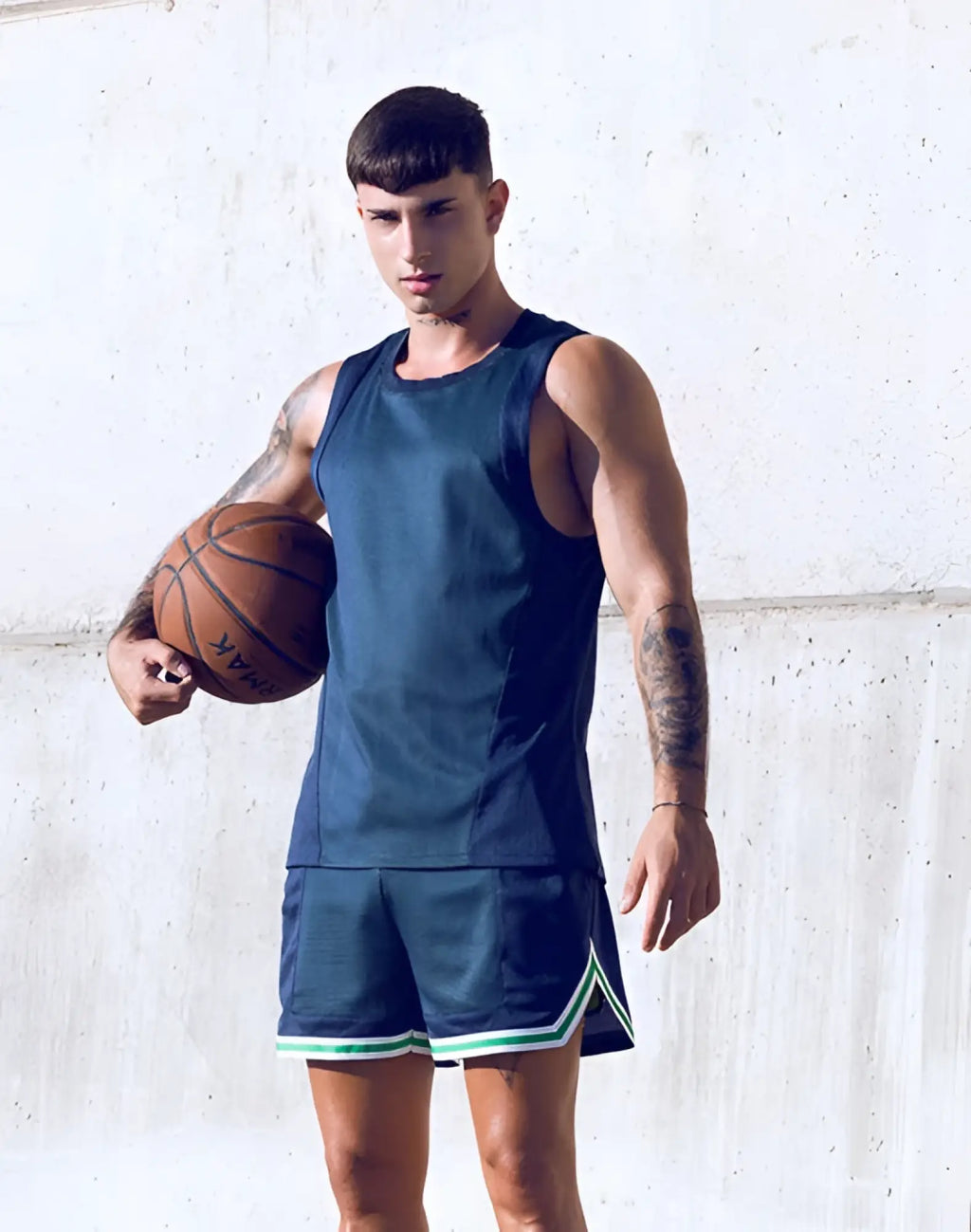 A man wearing a supawear swish mesh singlet in neon green with navy blue mesh basketball shorts trimmed in green and white