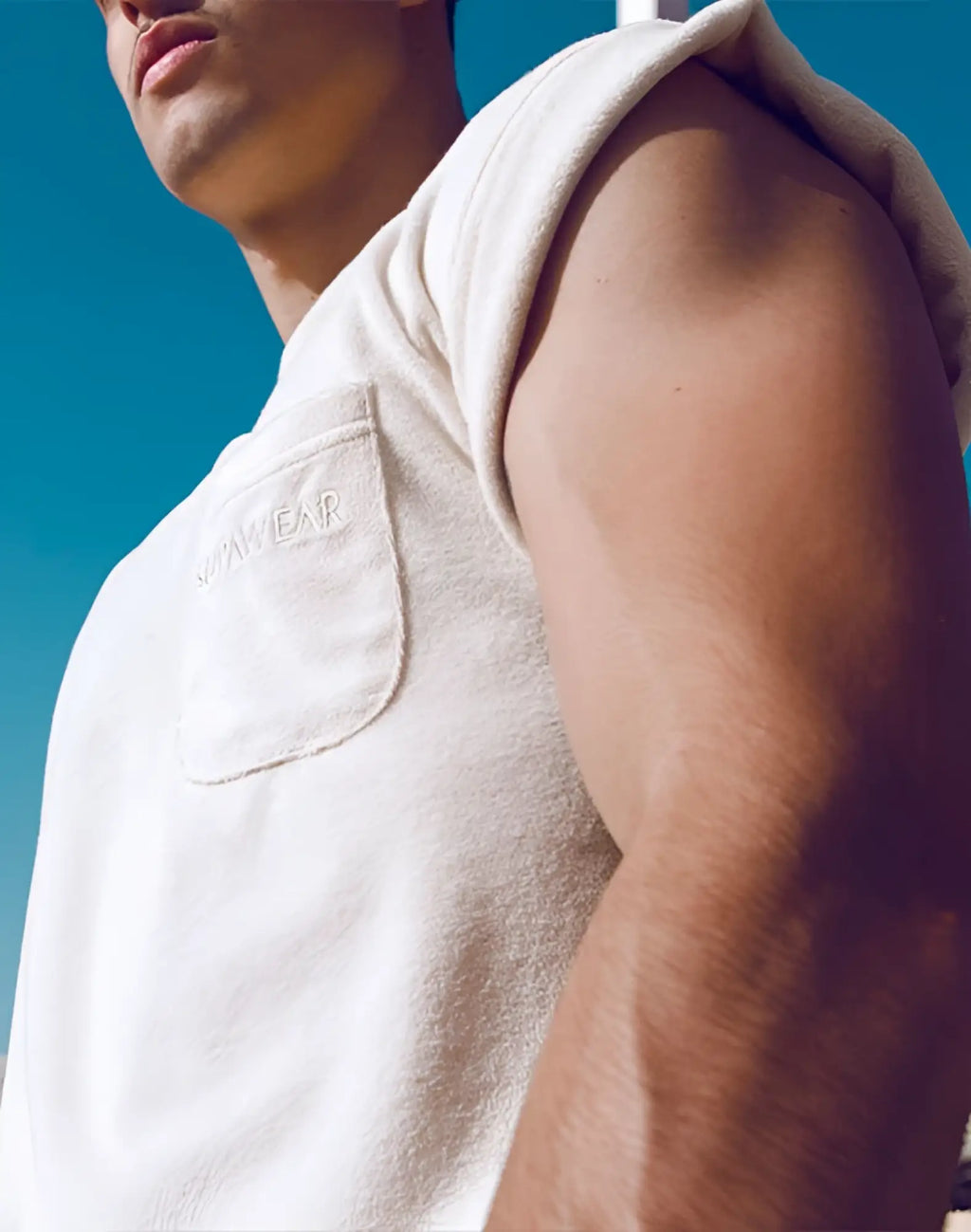 Cream-colored sleeveless hoodie with textured terry towelling fabric and front pocket embroidered with somawear brand name