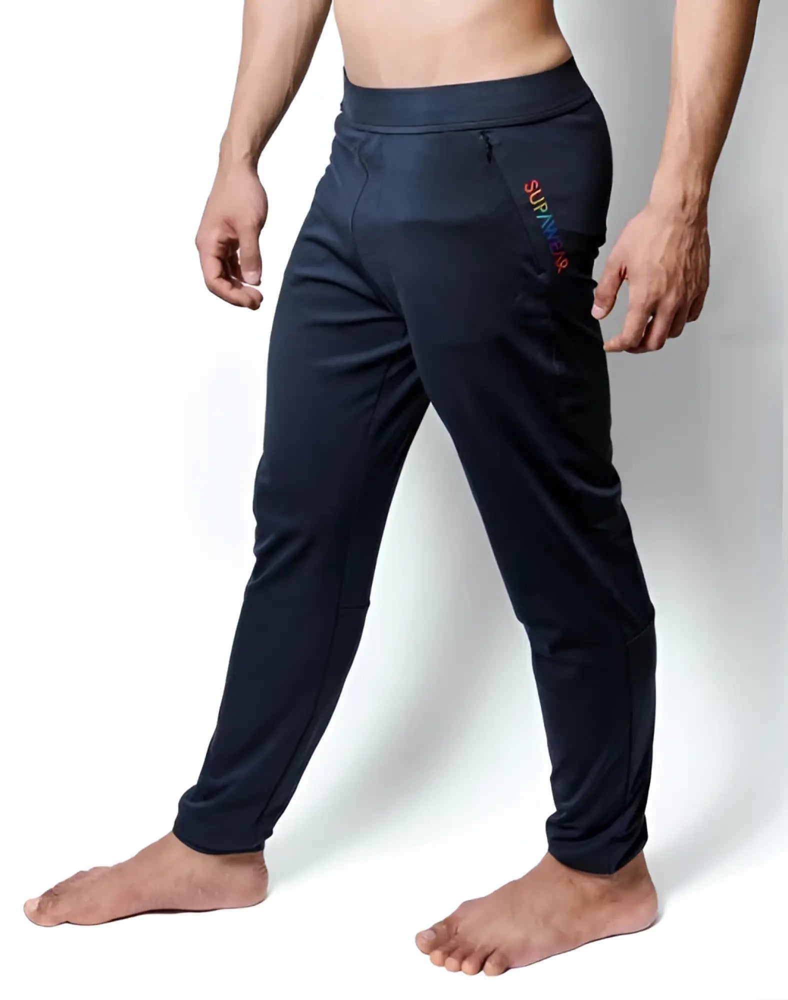 Black supawear training pants with snug elastic waistband and rainbow survivor branding on side seam