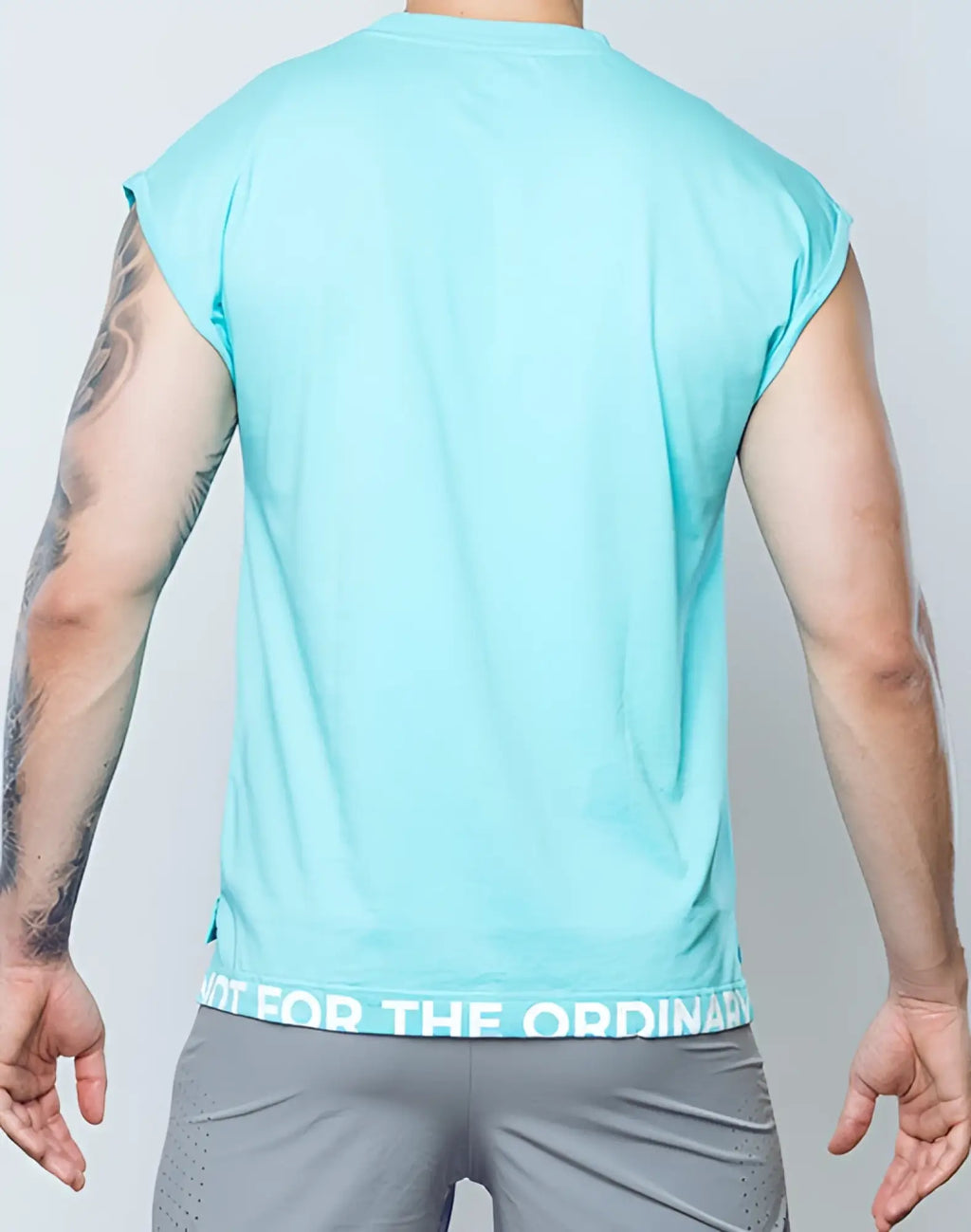 A light blue sleeveless SUPAWEAR wide-cut tank with a white text band at the hem for athletic use
