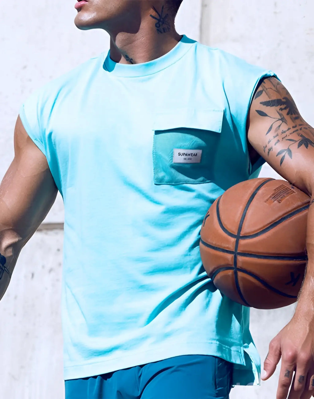Light blue sleeveless supawear wide-cut tank with mesh pocket and white brand label in turquoise blue