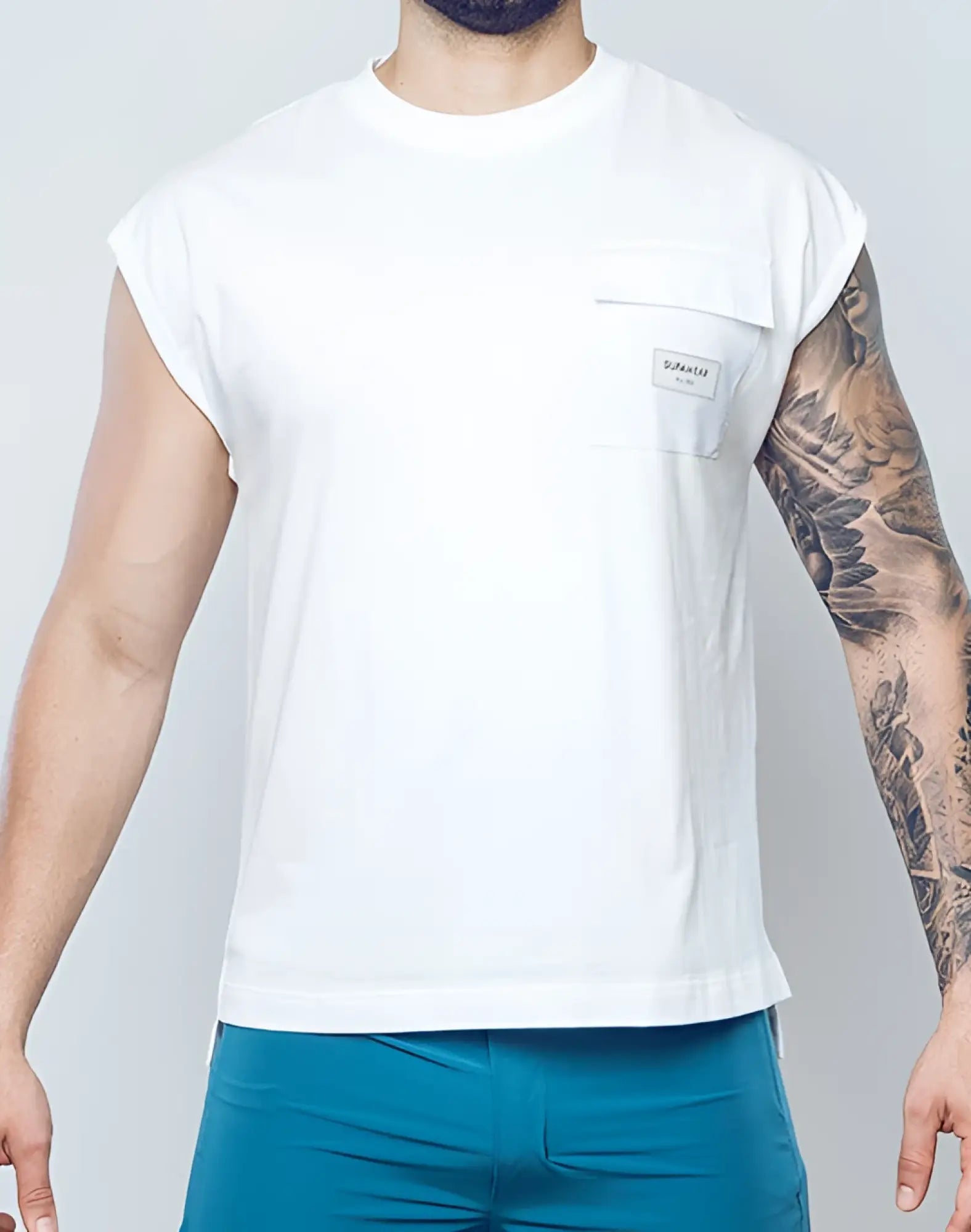 SupaWear wide-cut white sleeveless t-shirt with chest pocket and small rectangular brand label in cotton material