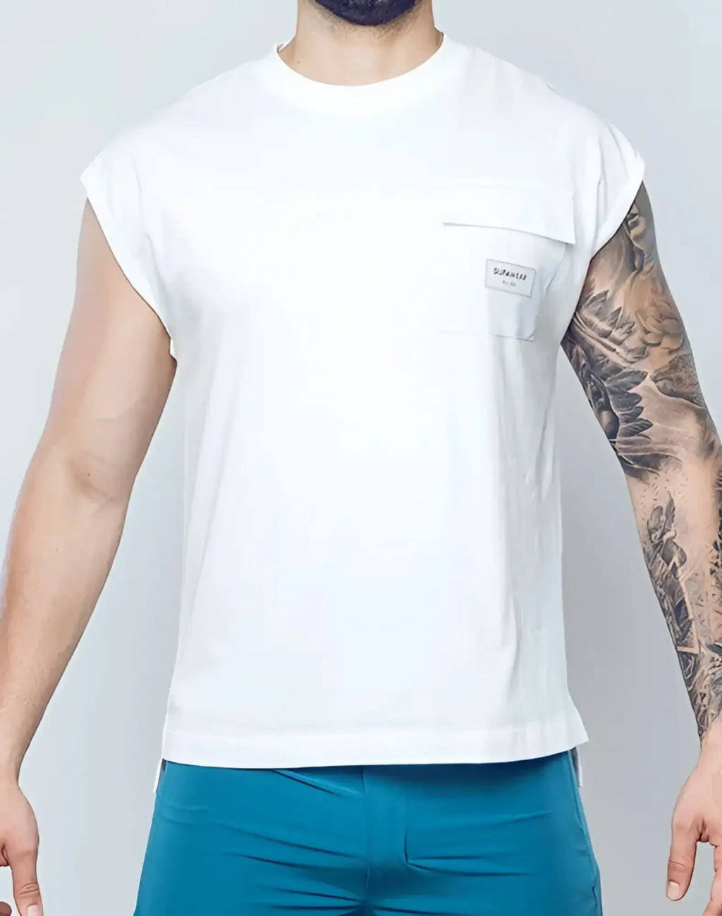 SupaWear wide-cut white sleeveless t-shirt with chest pocket and small rectangular brand label in cotton material