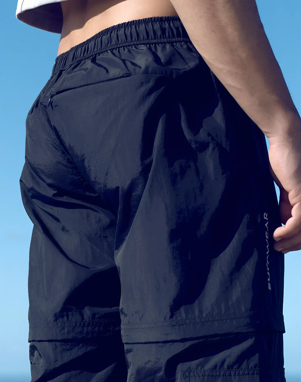 Black lightweight SUPAWEAR zip-off trouser shorts with elastic waistband and subtle sunwear logo for athletic use