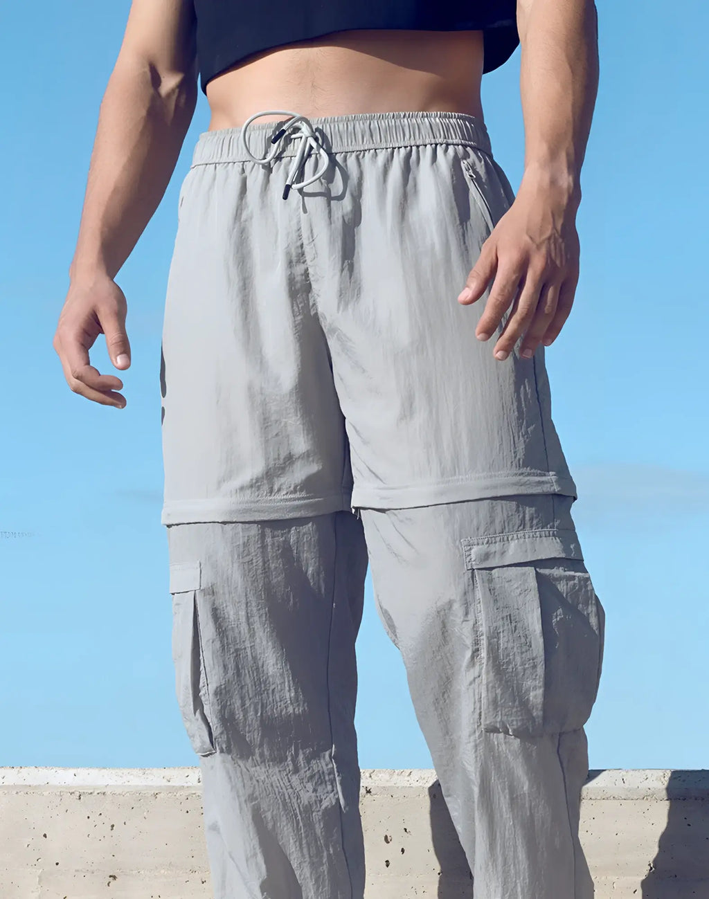 Light gray lightweight SUPAWEAR zip-off trousers with drawstring waist and multiple pockets for versatile wear