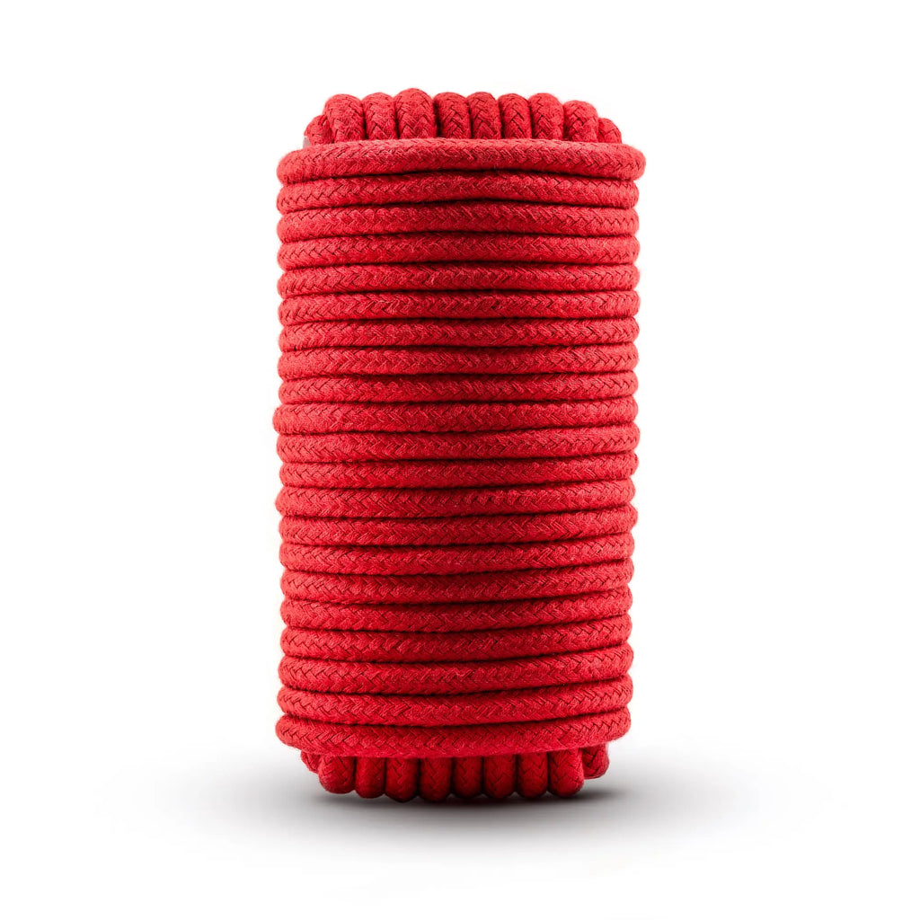 A neatly coiled 10m red Temptasia bondage rope braided with a textured surface for secure restraint