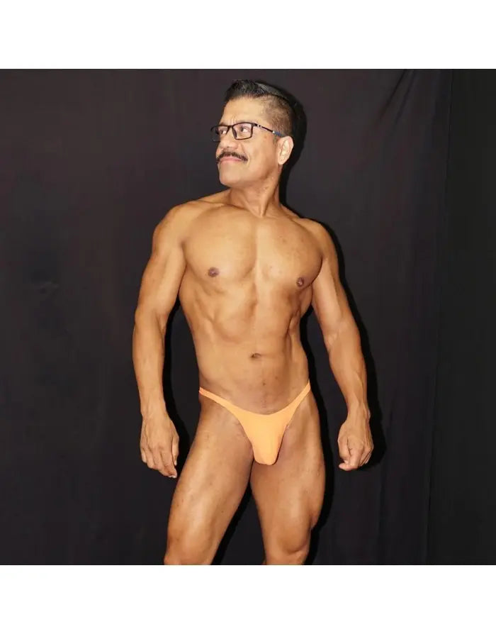 Model wearing Arroyman orange thong underwear featuring a minimal design and snug fit showcasing a smooth fabric.