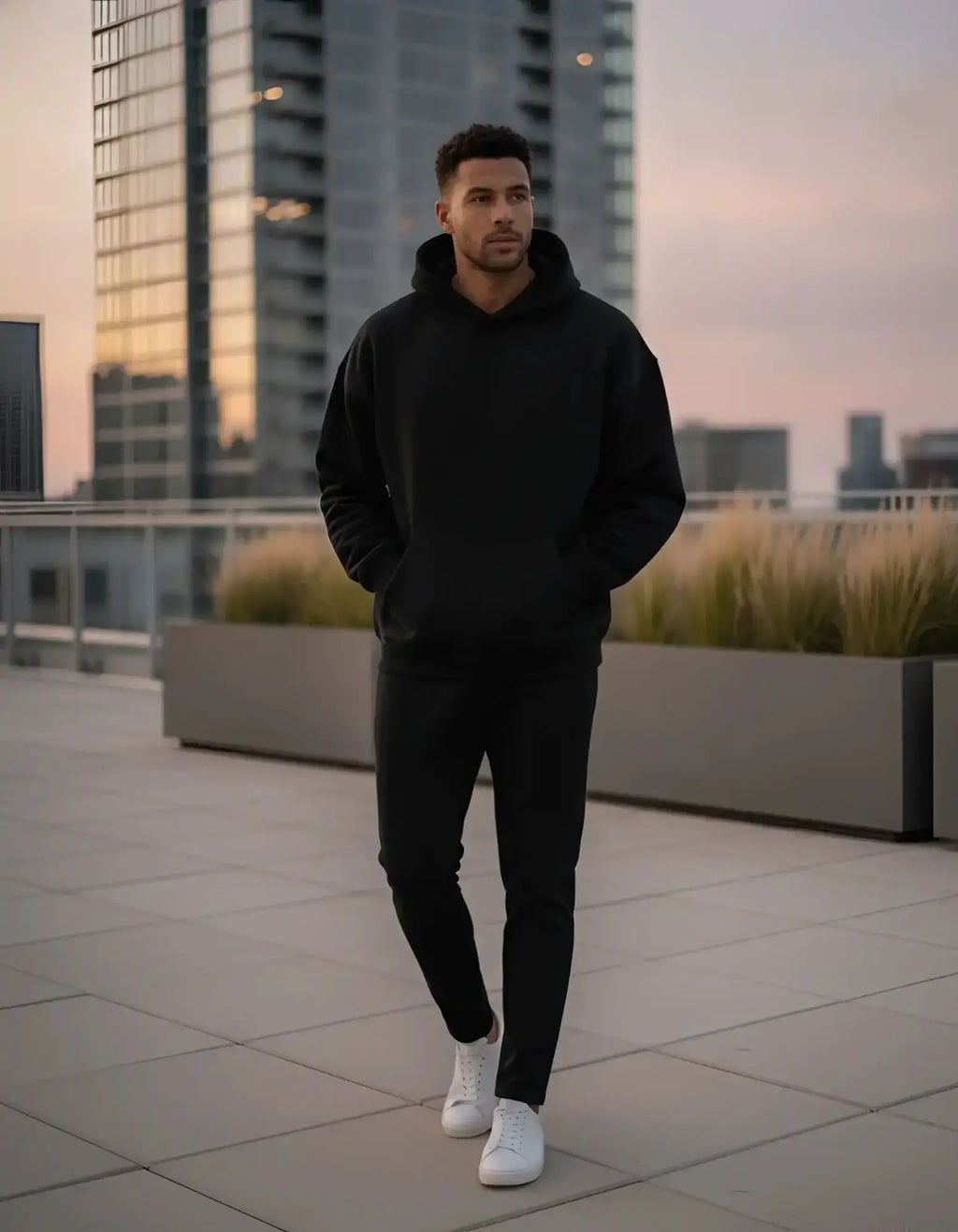 Solid black long-sleeve hoodie with a spacious hood, ribbed cuffs, and a large front kangaroo pocket.