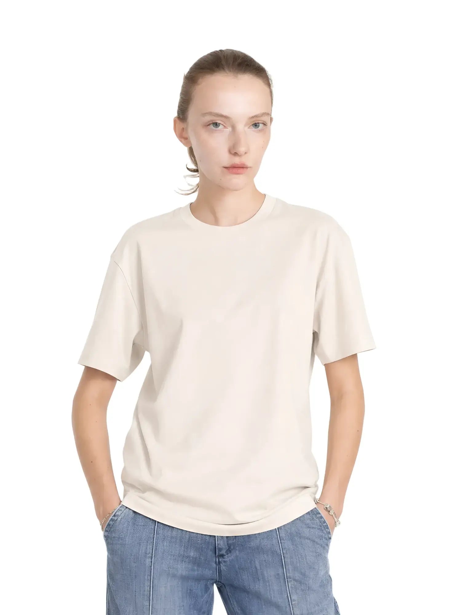 Model wears a cream-colored, relaxed-fit cotton core tee with a classic crew neck and short sleeves.