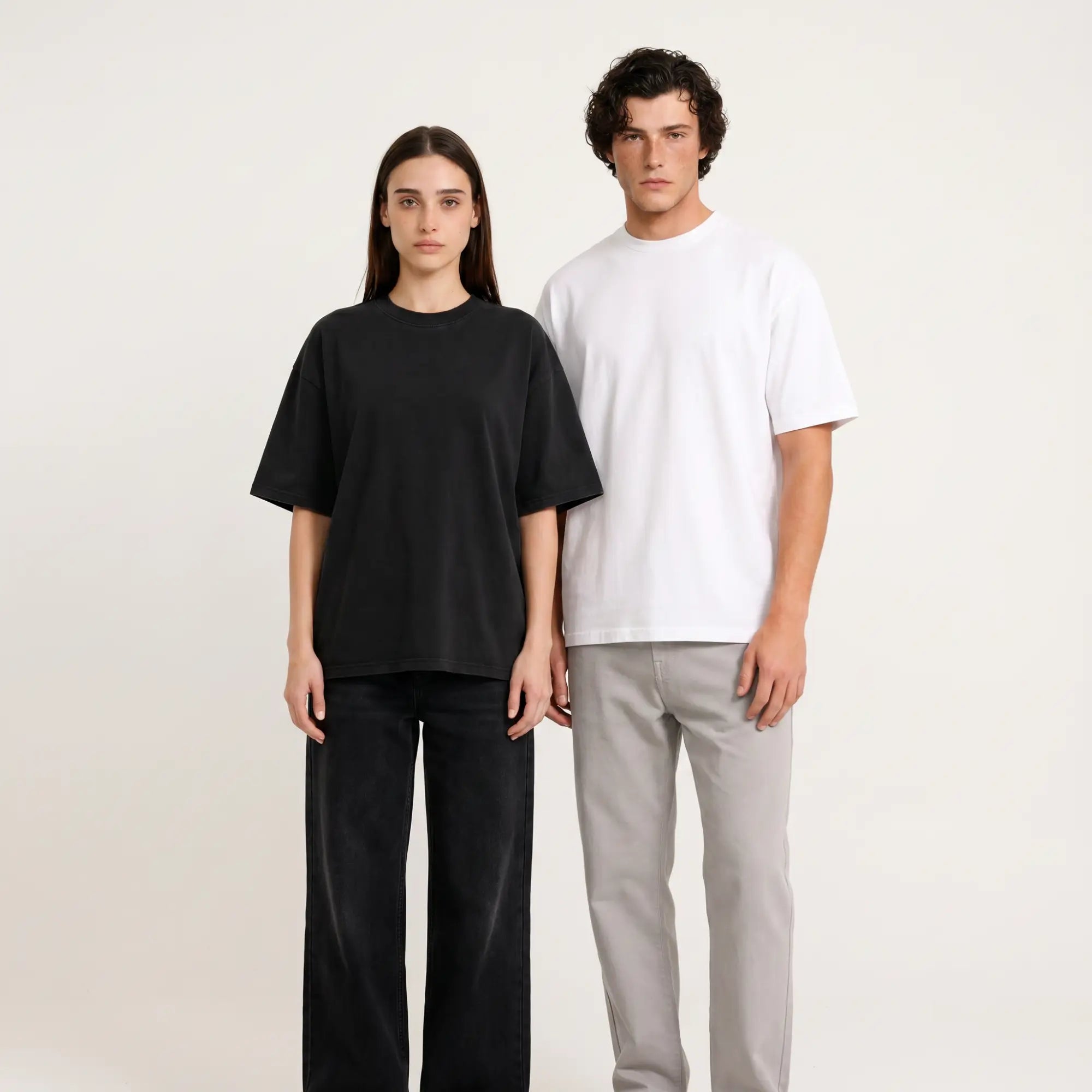 Woman in black and man in white Thread Lab Core Tees, oversized boxy fit, clean studio lifestyle photo.