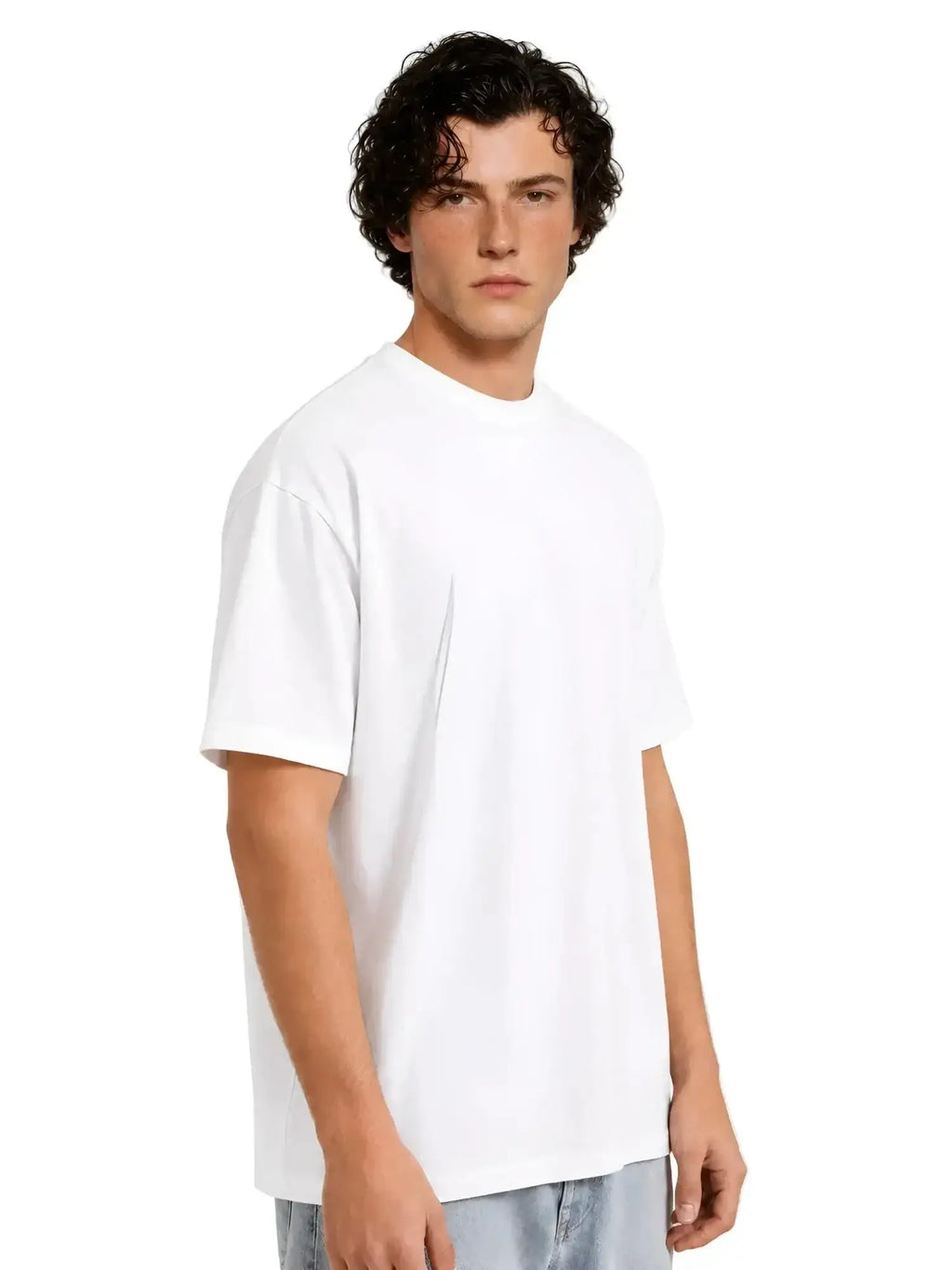 A man wears a plain, crisp white short-sleeved crew neck t-shirt with a relaxed, boxy fit.