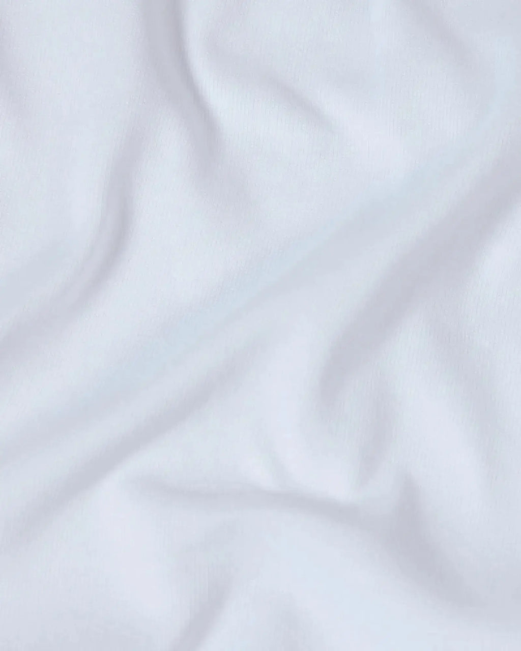 Close-up of a soft, white premium cotton fabric with gentle folds, showing a fine-knit texture.