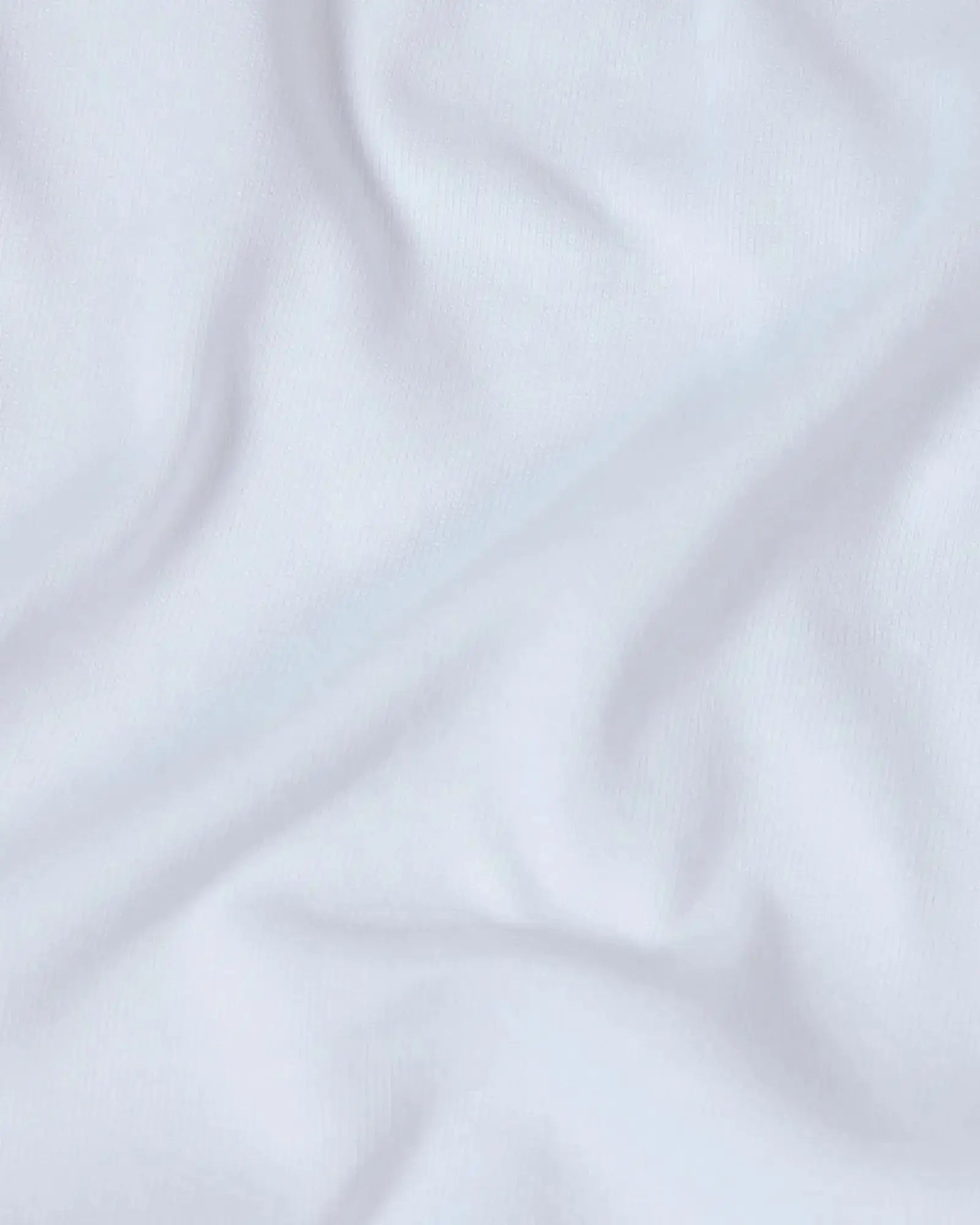 Close-up of a soft, white premium cotton fabric with gentle folds, showing a fine-knit texture.