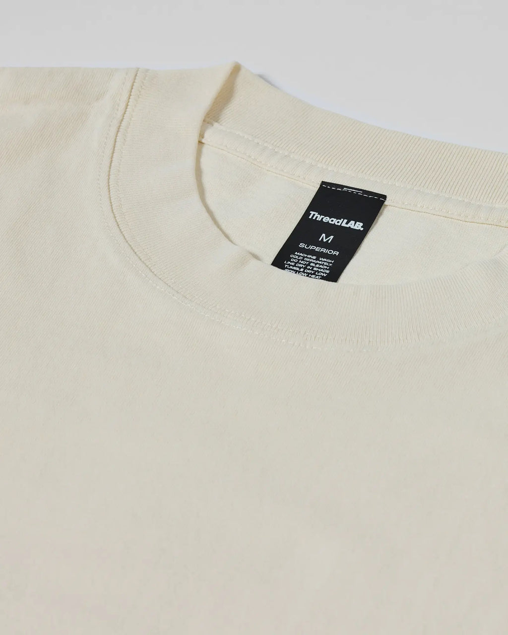 Cream-colored crewneck t-shirt with a detailed ThreadLAB Superior interior neck label.
