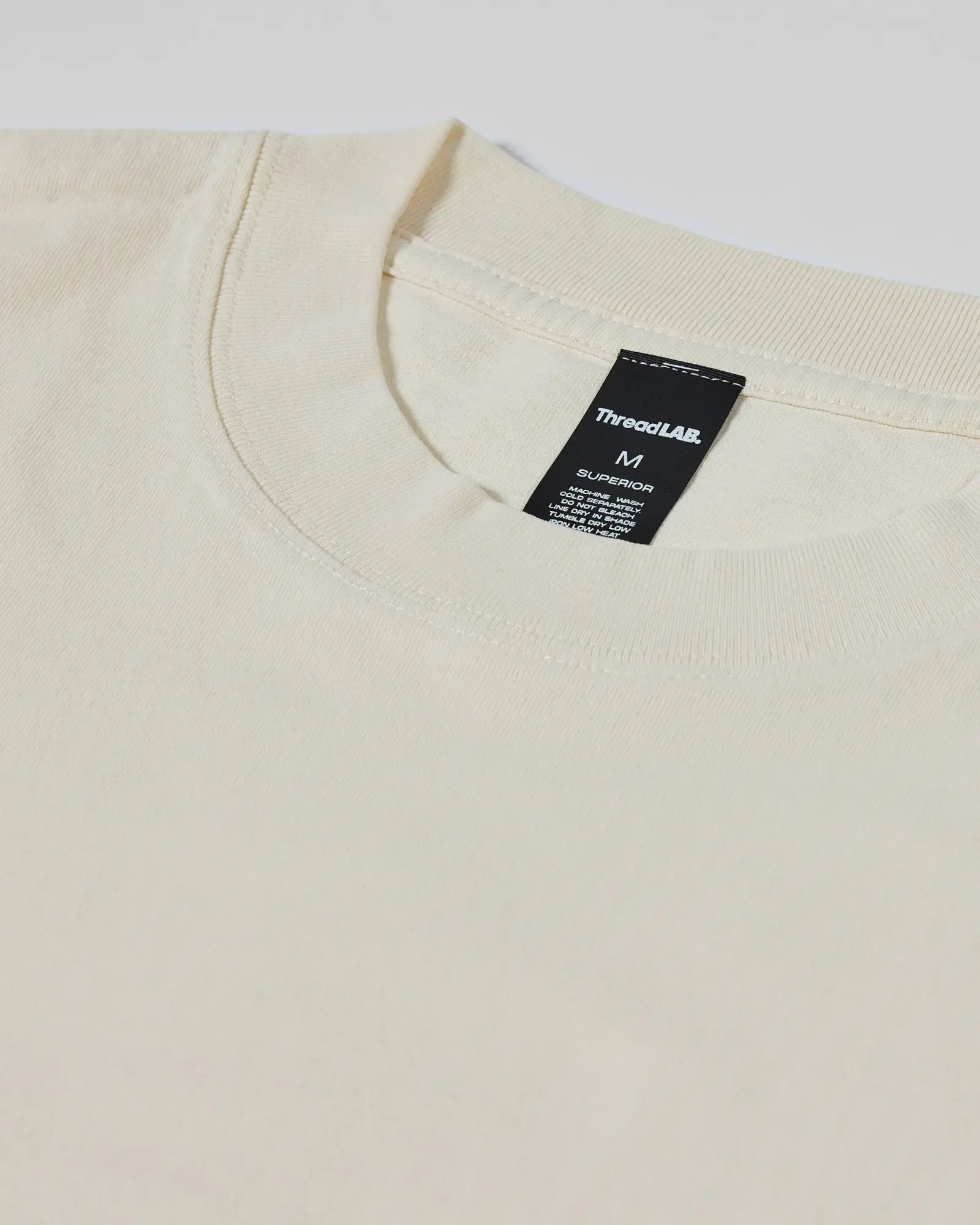 Cream-colored crewneck t-shirt with a detailed ThreadLAB Superior interior neck label.