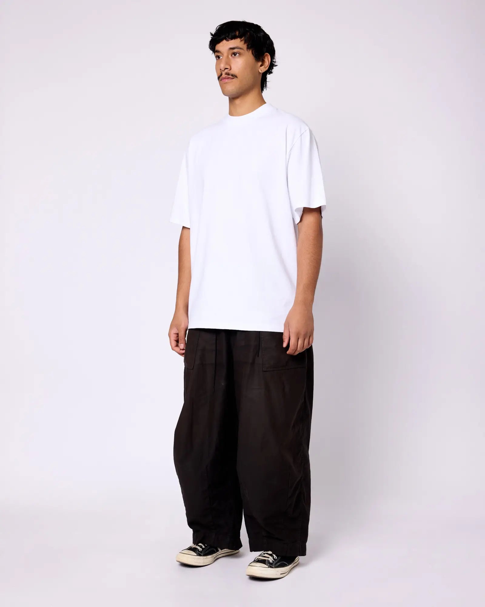 Model wearing a classic white crewneck short-sleeve tee with a clean, boxy fit against a white background.
