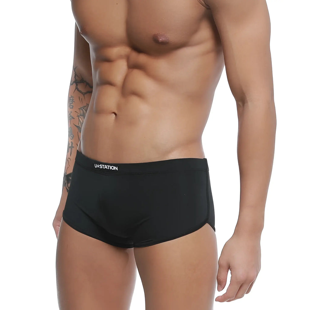 Black ua station briefs with sleek form-fitting design and subtle white branding on the waistband u-station brazilian trunk