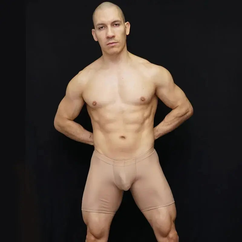 Nude ultra biker cycle shorts by Arroyman featuring a snug fit and smooth material modeled by a man against a black background.