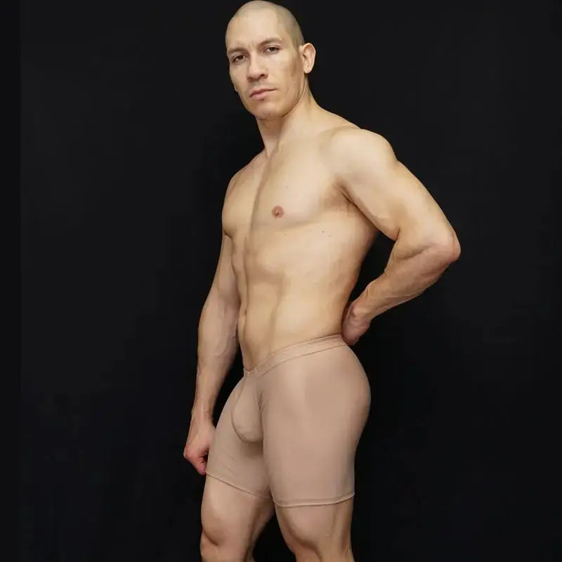 Nude ultra biker cycle shorts by Arroyman featuring a snug fit and smooth material modeled by a man against a dark background.