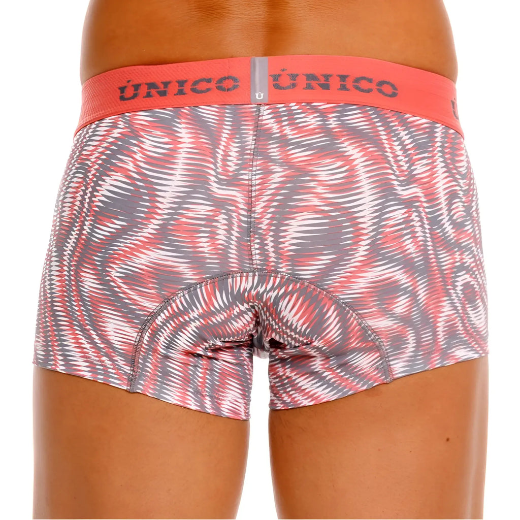 A pair of unico 26020100116 acanalado trunks in pink with a dynamic swirl pattern and an orange waistband