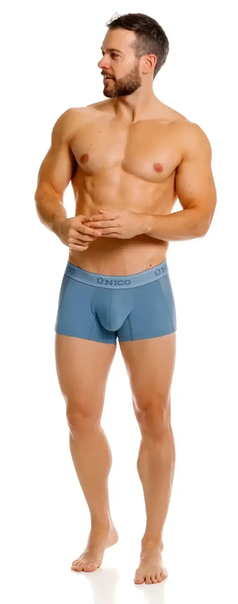 Front view of Unico Classic Trunks in 46-Blue, modeled by a shirtless man standing on a white background.