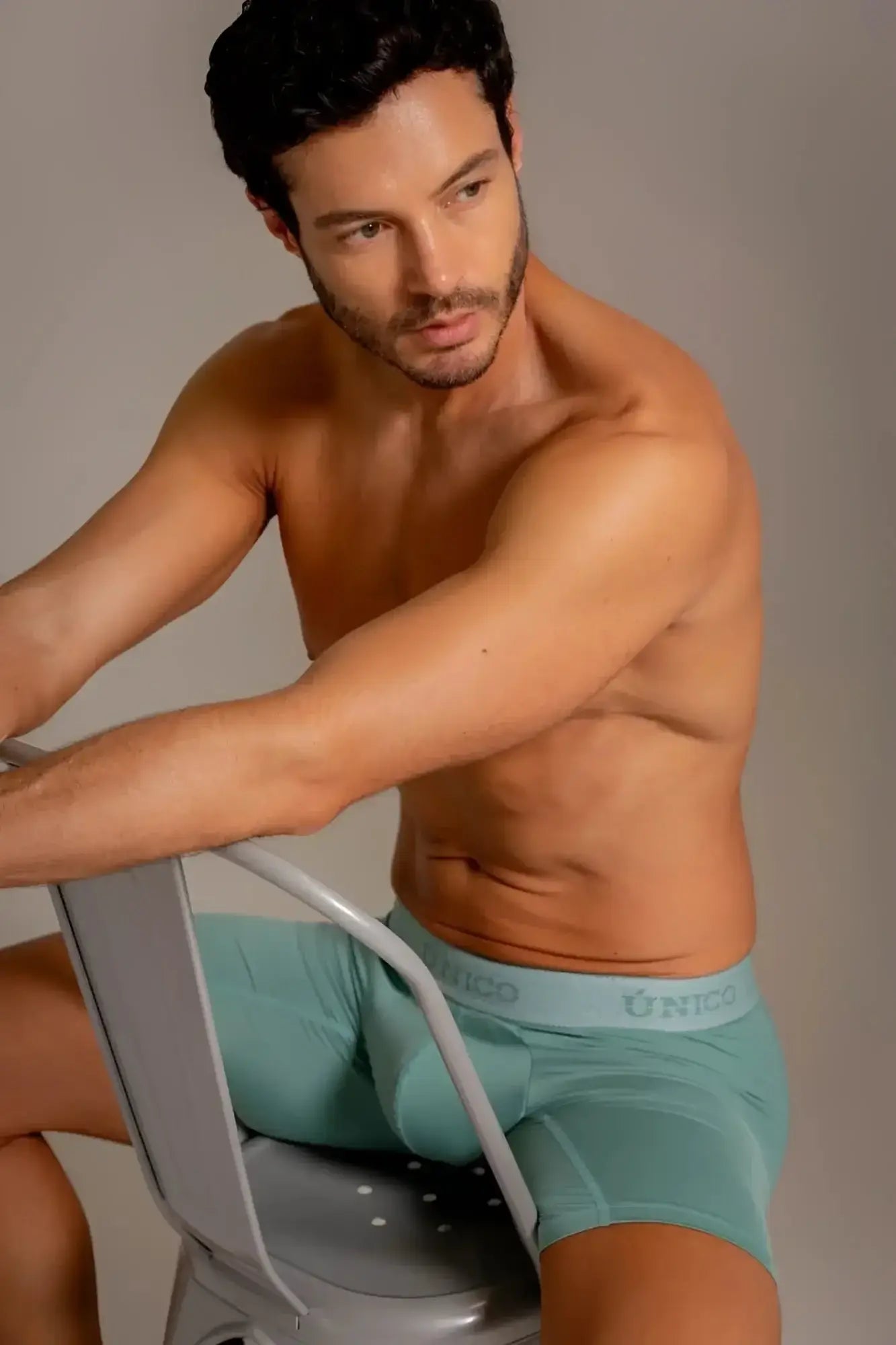 Unico Ceramic boxer briefs in green, lifestyle shot of a man sitting on a chair.
