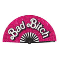 Wood Rocket bad bitch folding fan vibrant pink glitter with bold white cursive lettering and black-and-white striped interior