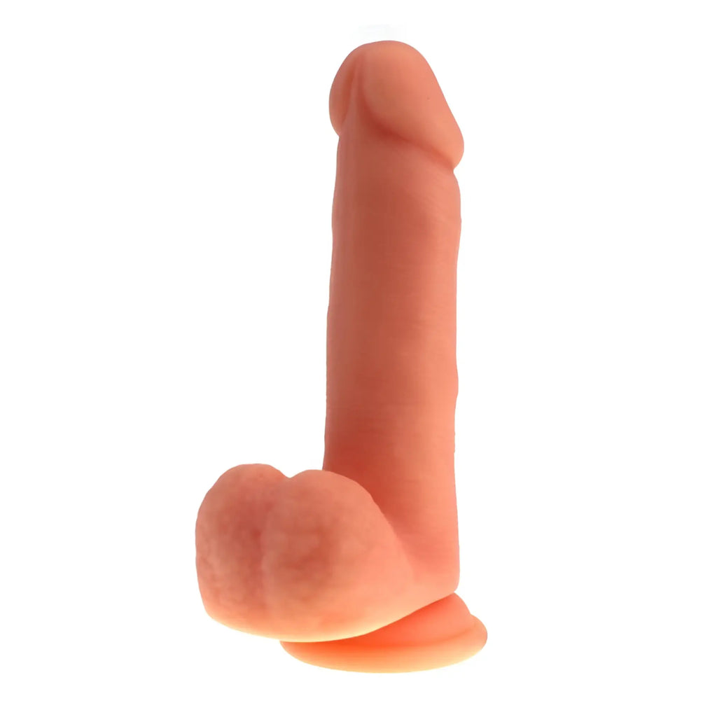 Peach-colored thick realistic silicone cock with balls featuring a tapered head and rounded base for adult use
