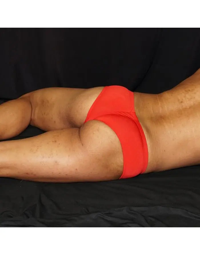 Red boxer underwear by Arroyman featuring a snug fit and smooth fabric shown on a model from the side.