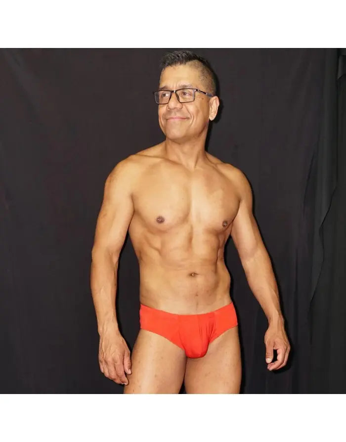 Red men's boxer underwear by Arroyman featuring a snug fit and soft fabric modeled by a man with glasses.